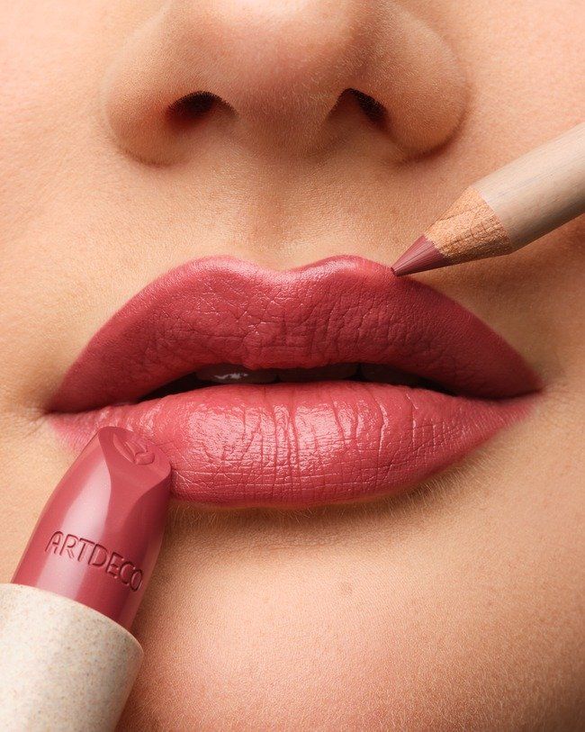 Una donna si applica il rossetto sulle labbra con una matita.