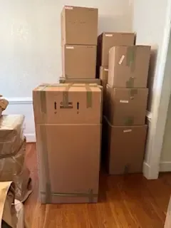 A bunch of cardboard boxes are stacked on top of each other in a room.