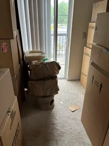 A room filled with boxes and a sliding glass door.