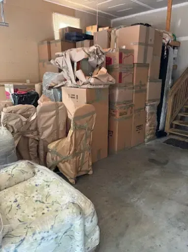 A garage filled with lots of moving boxes and furniture.