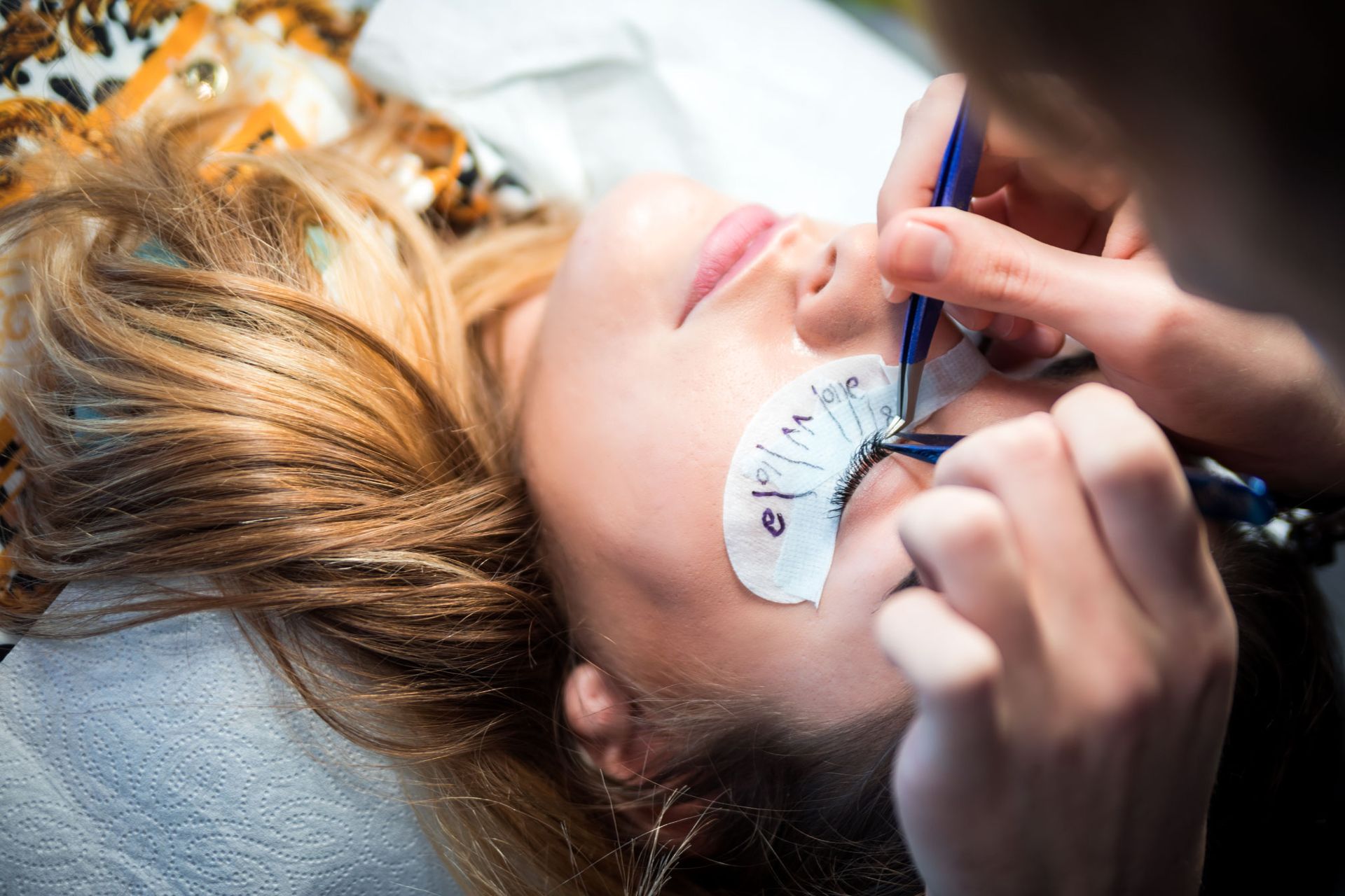 A woman getting eyelash extensions. 