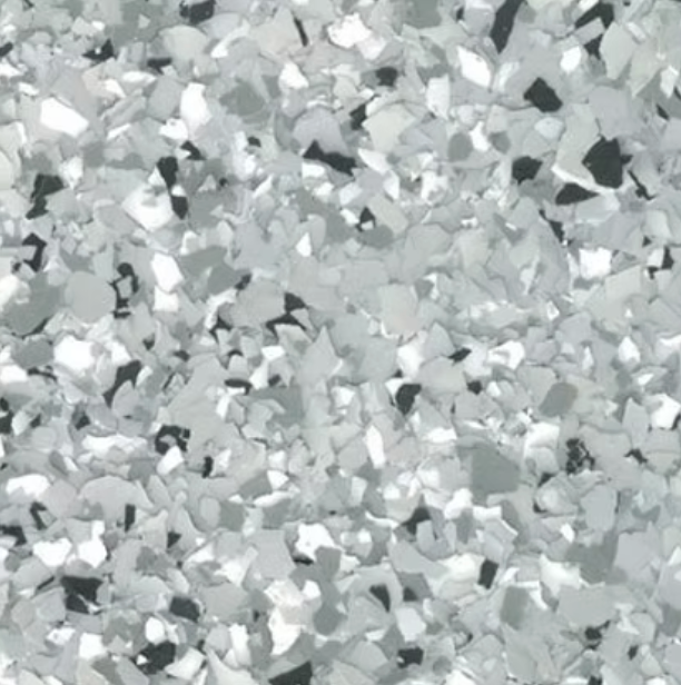 Close-up of a speckled flooring surface with gray, silver, and black chips.