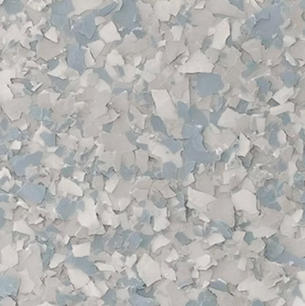 Close-up of a speckled floor coating, featuring a mix of white and pale blue chips.