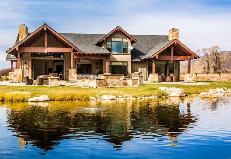 A large house is sitting next to a body of water.