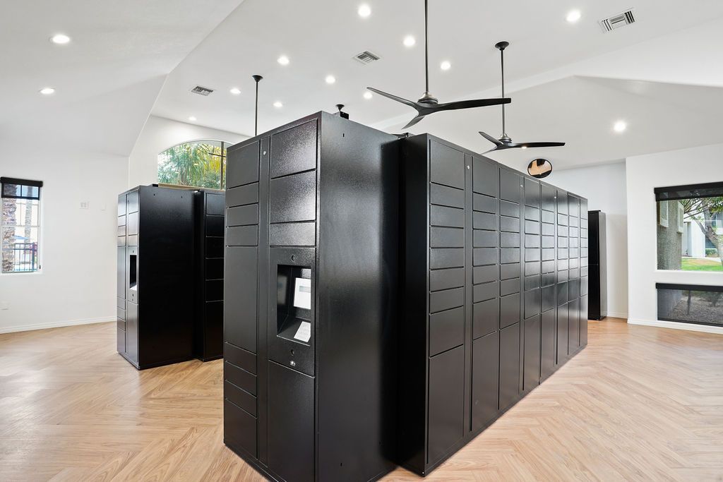 Row of tall black storage lockers in a bright, modern community room.