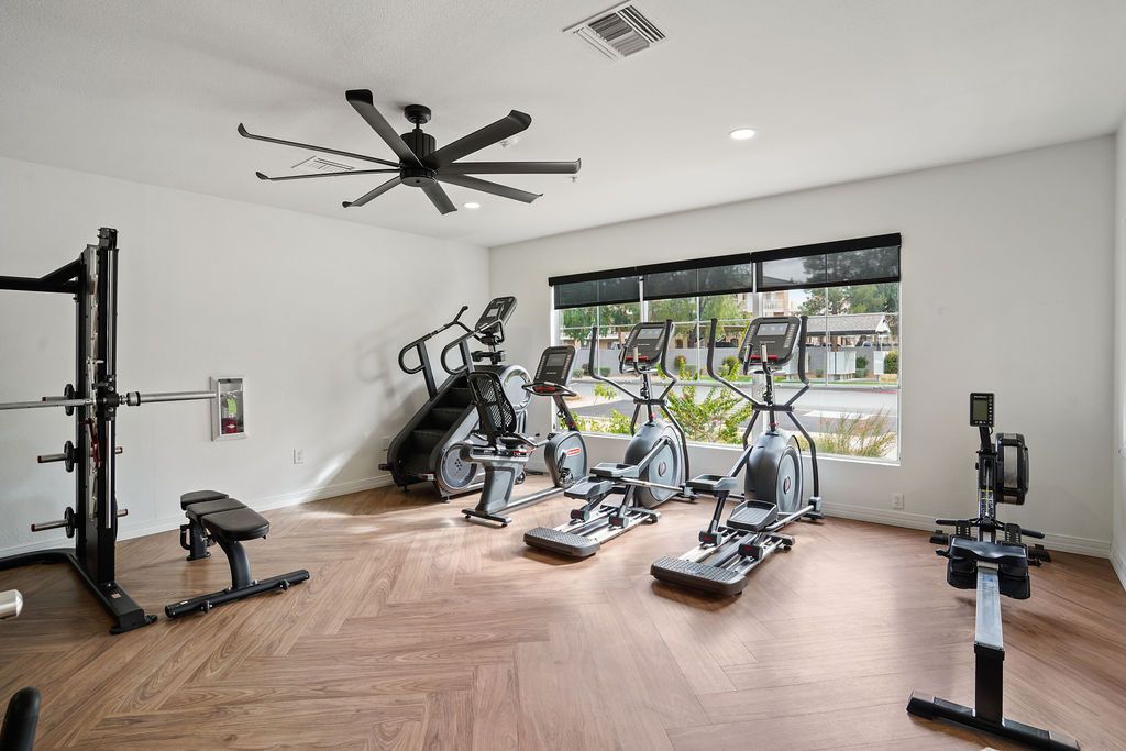 Interior community gym with treadmills, weight rack, and a bench.