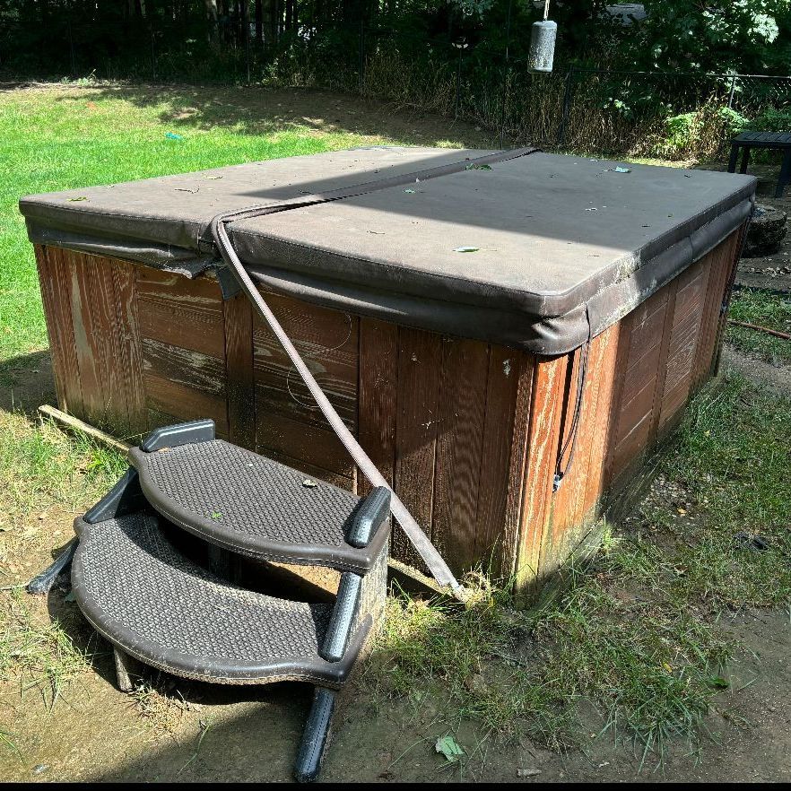 A hot tub is sitting on top of a wooden deck.