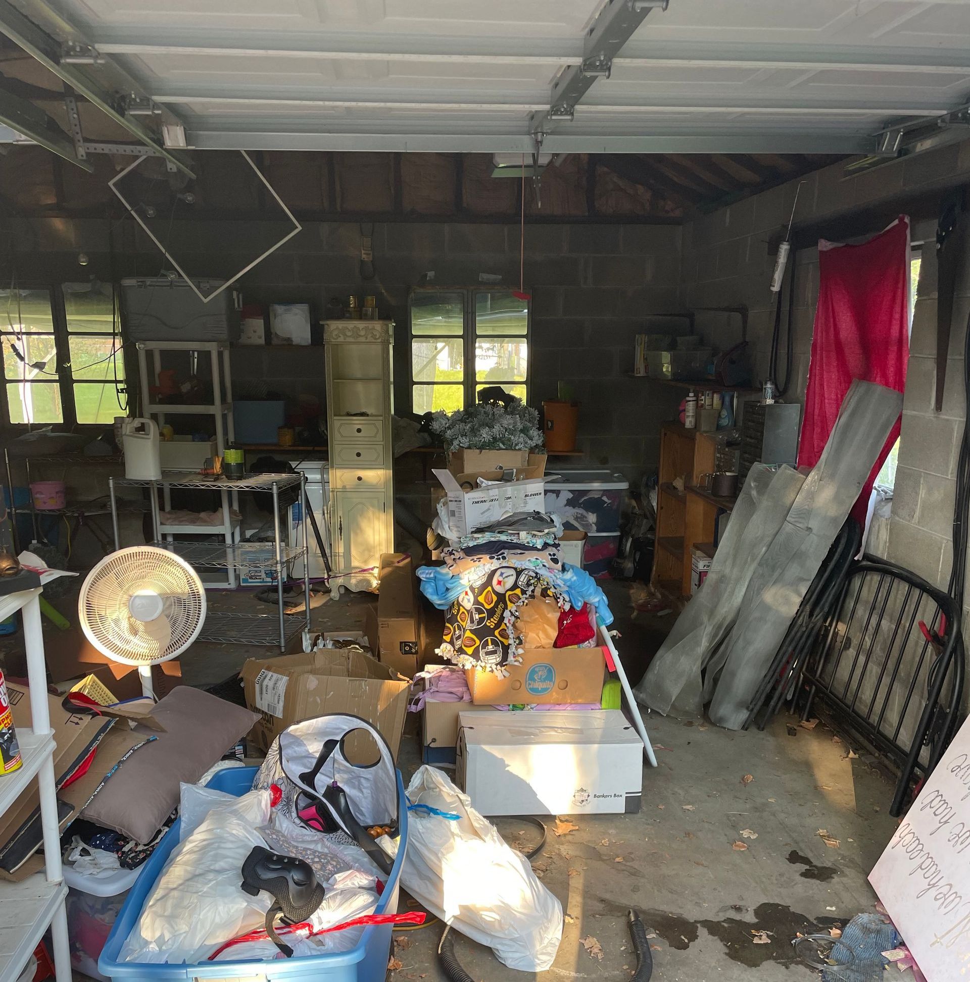 A garage filled with lots of junk and a fan