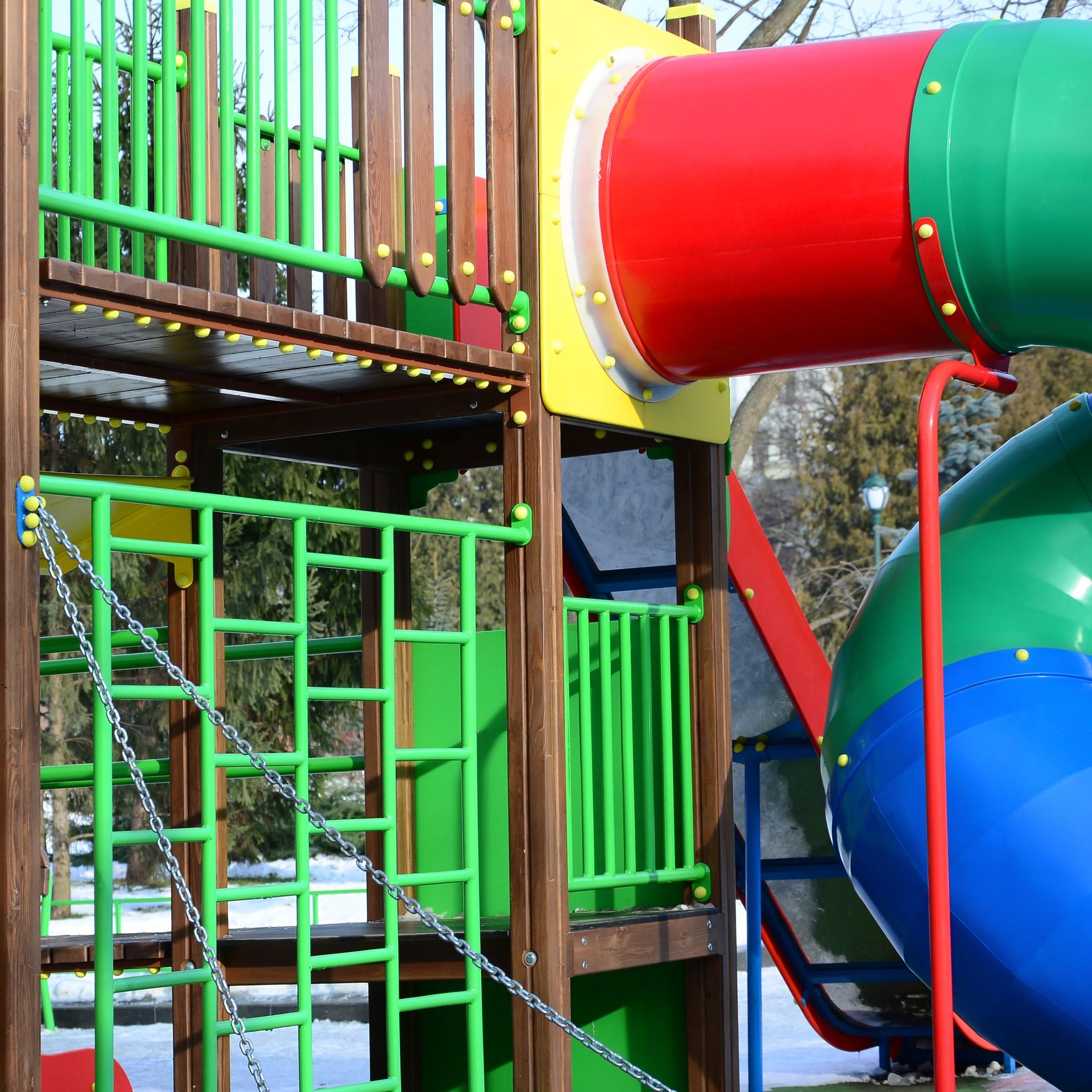 A colorful playground with a red green and blue slide