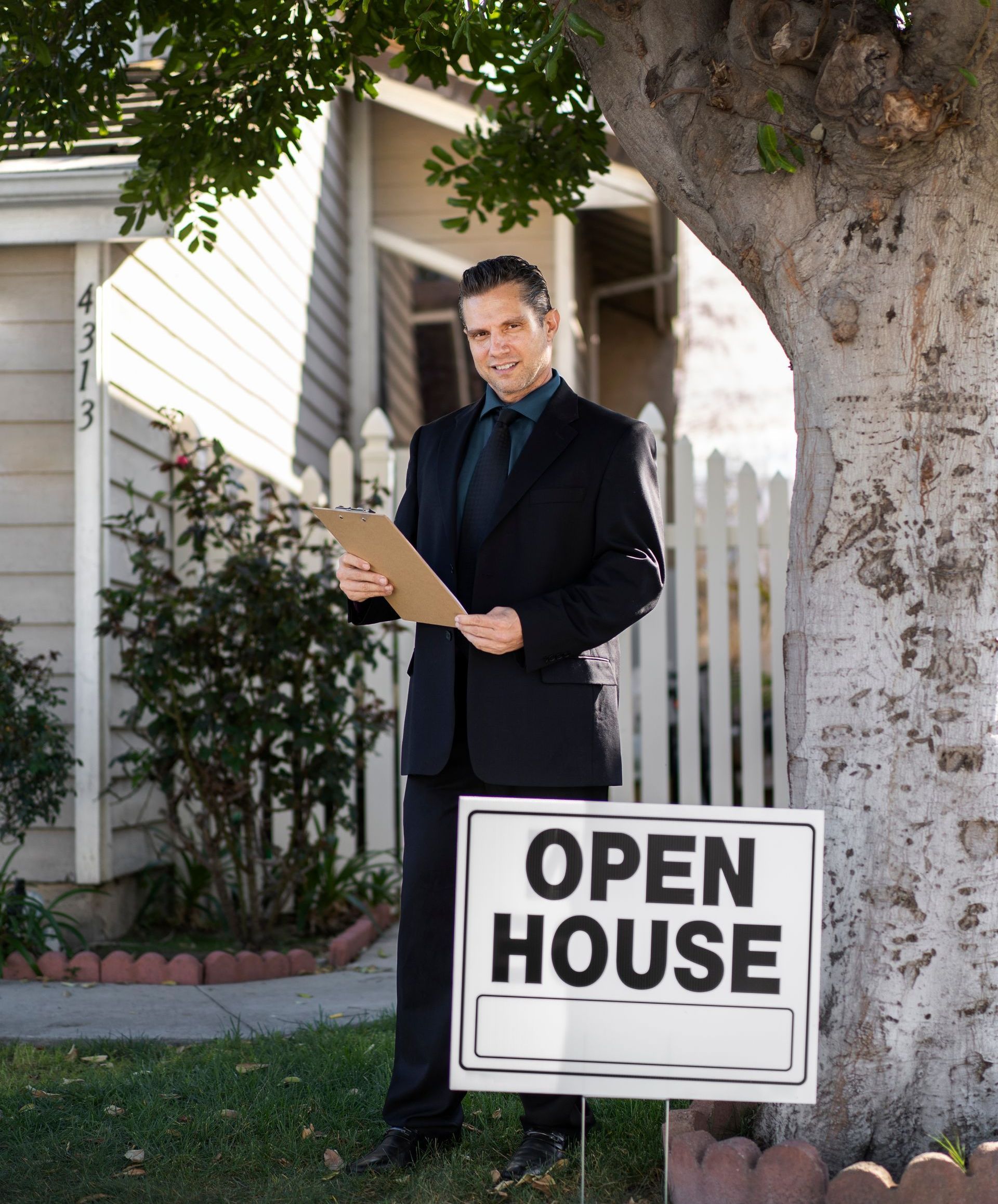 A man standing next to an open house sign