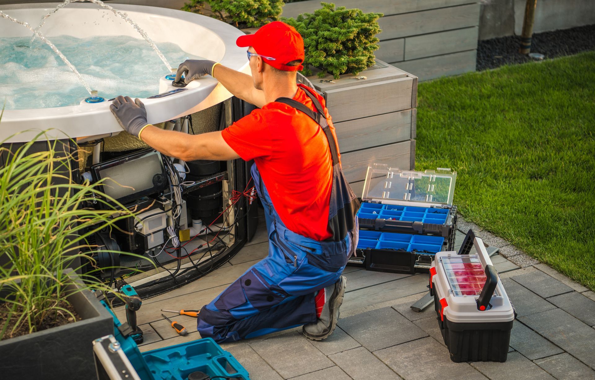 A man is repairing a hot tub on a patio.