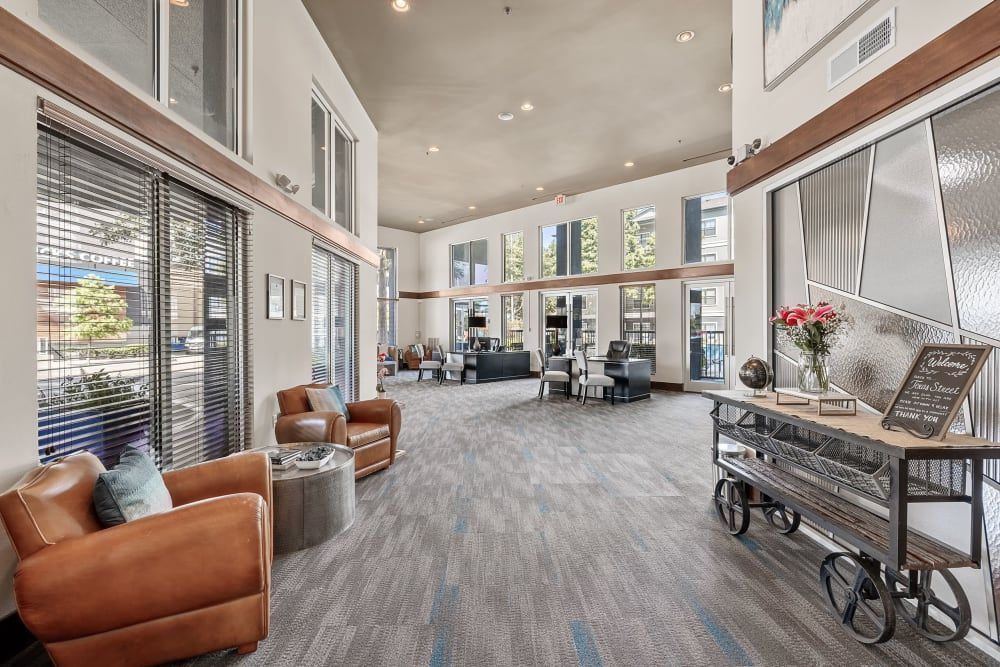 Clubhouse with many chairs and tables in the lobby at Marquis at Texas Street in Dallas, TX.
