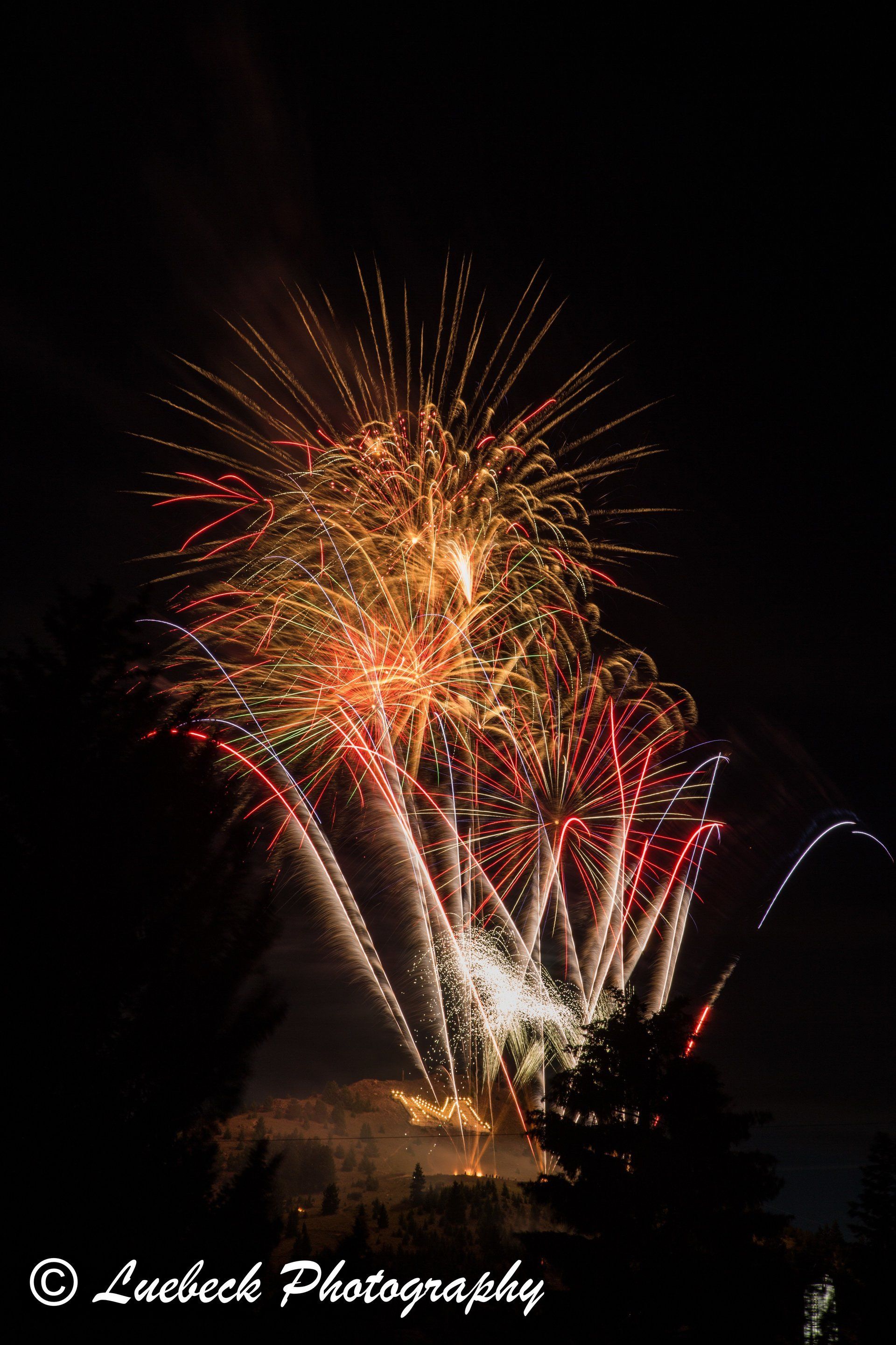 Joe Luebeck Fireworks exploding in the night sky over  Butte, MT