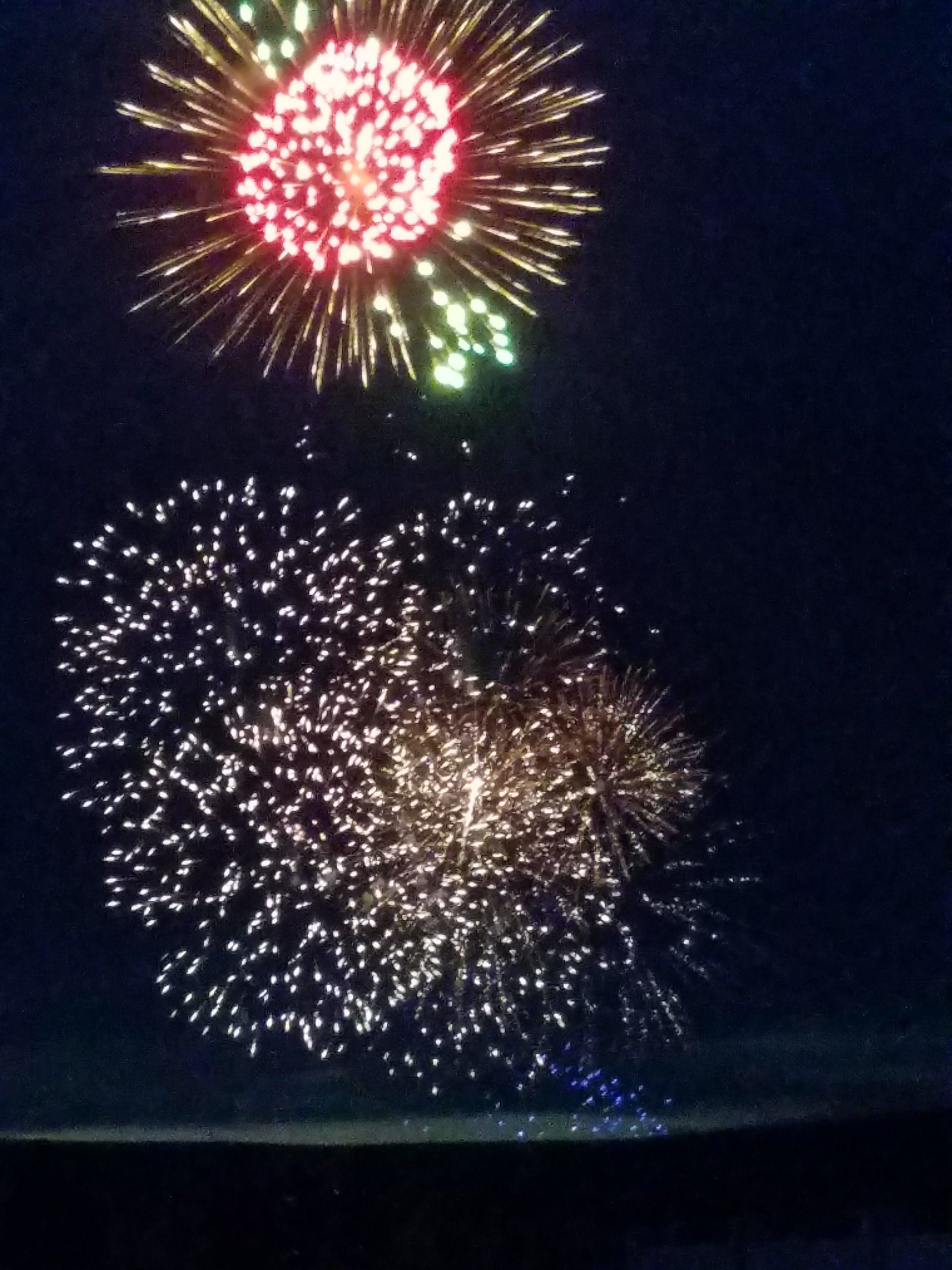 Kellee May Fireworks exploding in the night sky over  Butte, MT