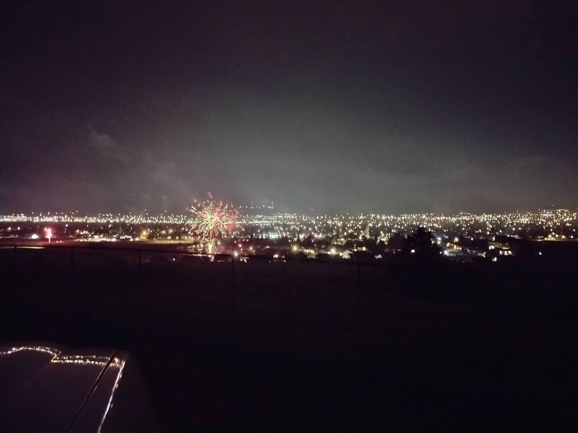 Fireworks exploding in the night sky over  Butte, MT from quite a distance