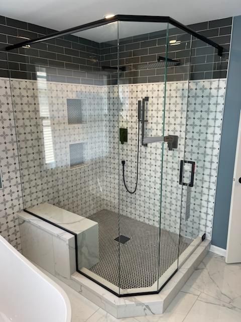 A bathroom with a sink , toilet , shower and mirror.