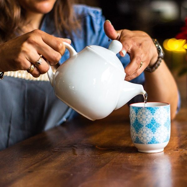 woman pouring herbal tea as part of proactive healthcare