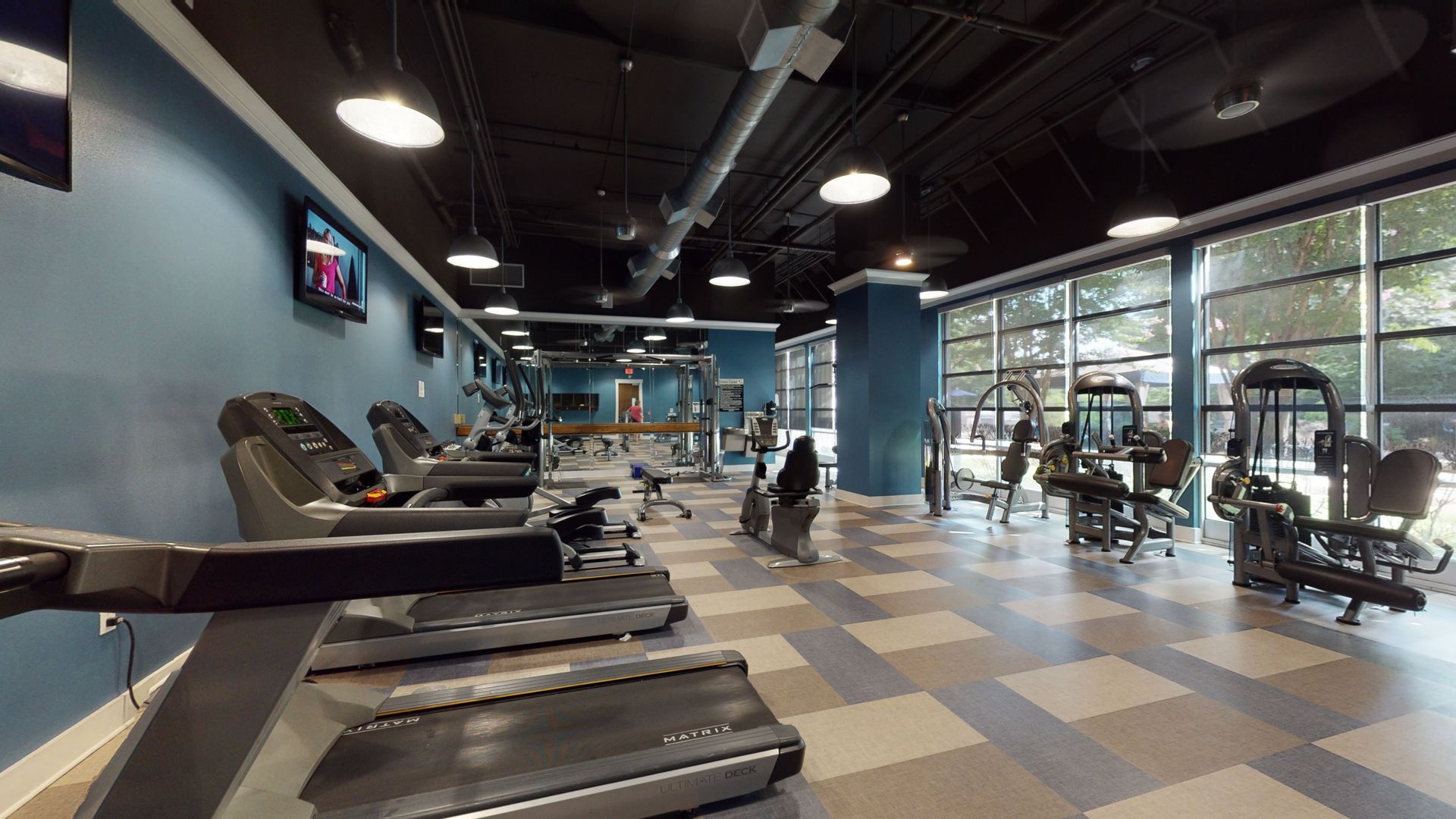 A gym with a lot of treadmills and exercise equipment.