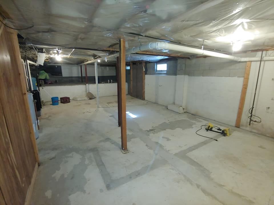 A very large empty basement with a lot of pipes coming out of the ceiling.