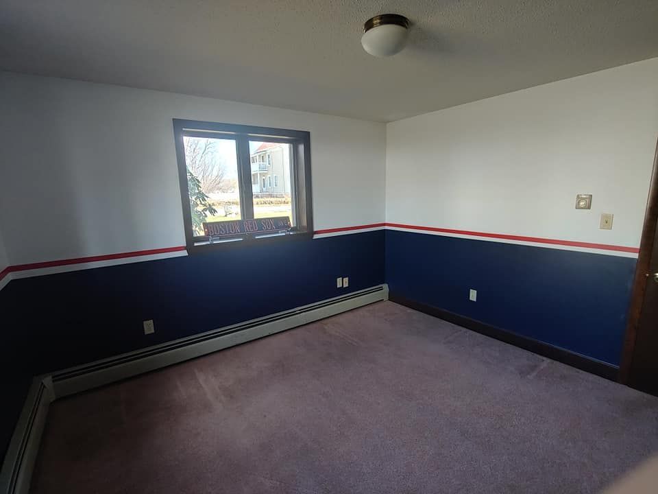 An empty room with blue and white walls and a window