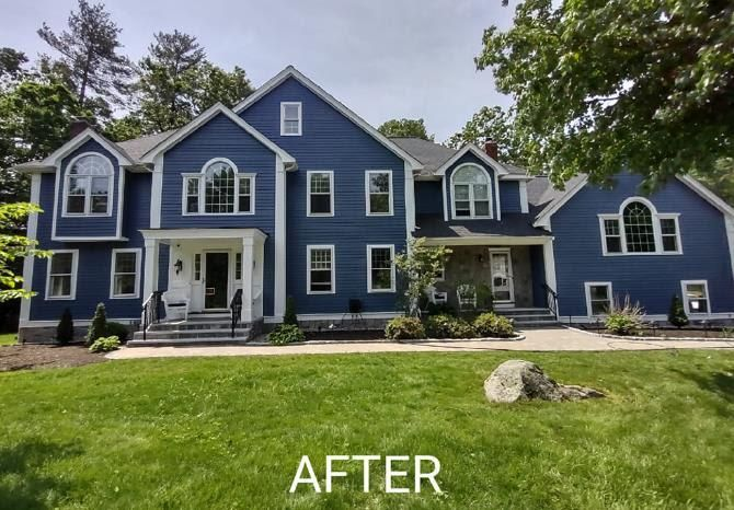 A large blue house with white trim is shown after being painted