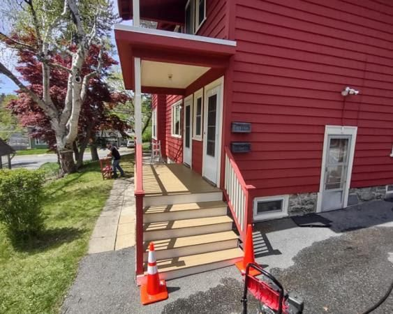 A red house with a porch and stairs