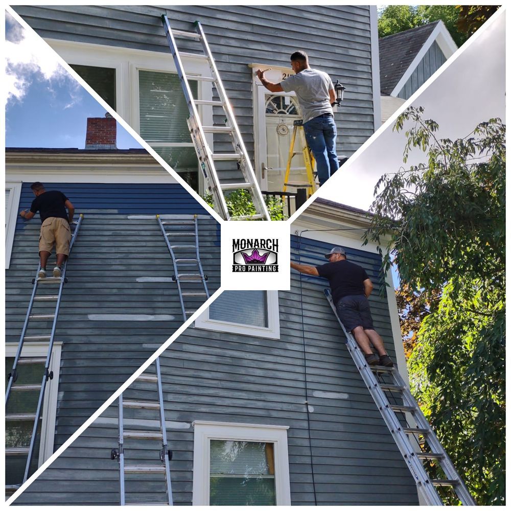 A man on a ladder paints the side of a house