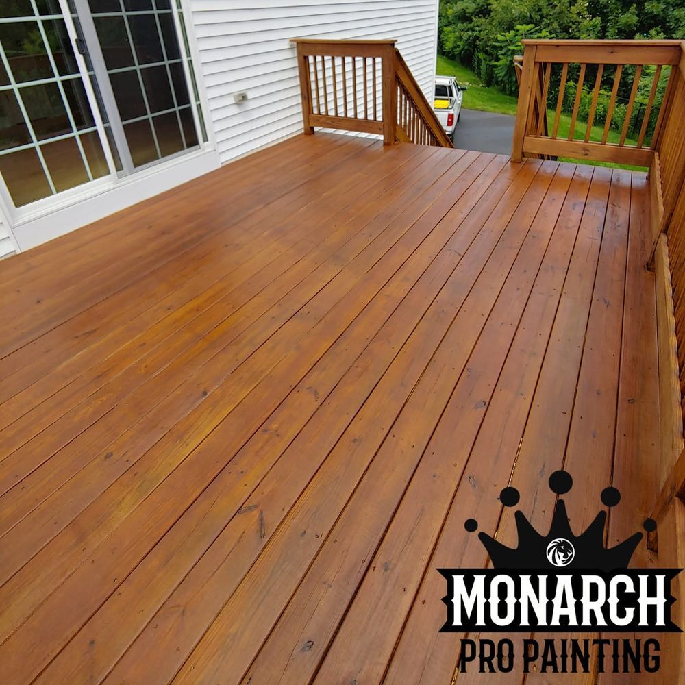 A wooden deck is being painted by monarch pro painting