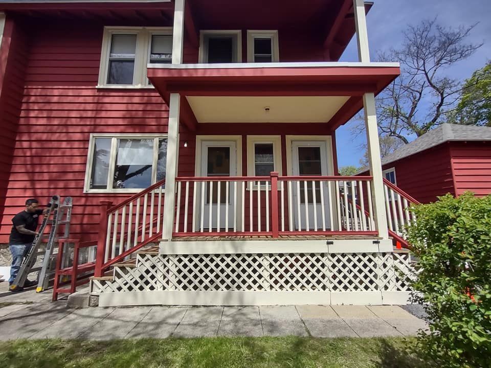 A red house with a white porch and stairs