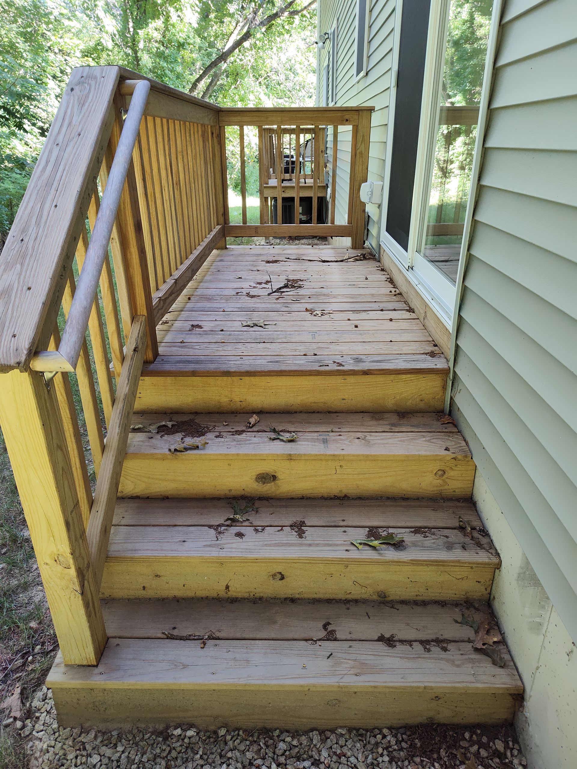 A wooden deck with yellow steps and a yellow railing