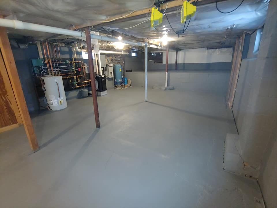 A basement with a concrete floor and a water heater.