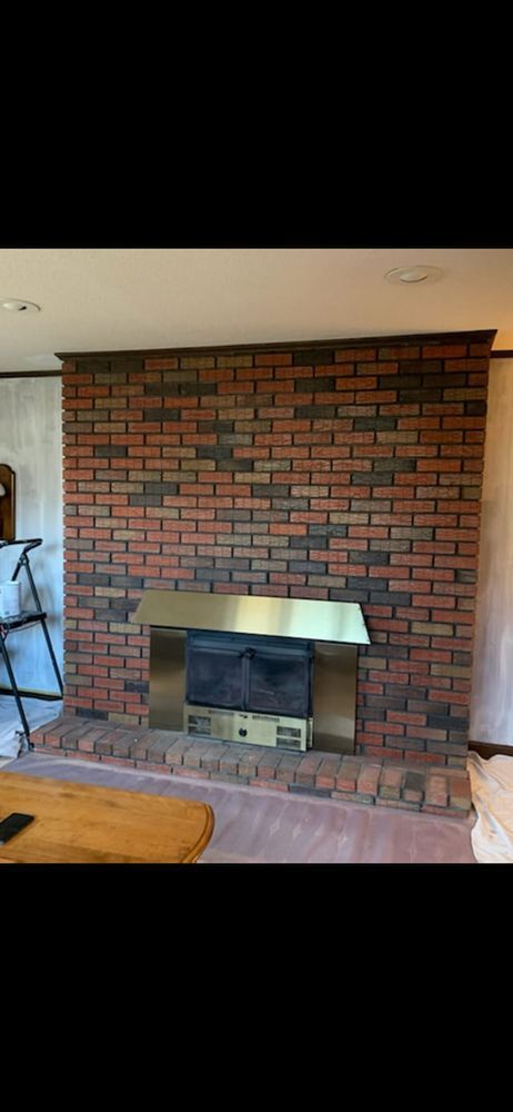A living room with a brick fireplace and a wooden table.