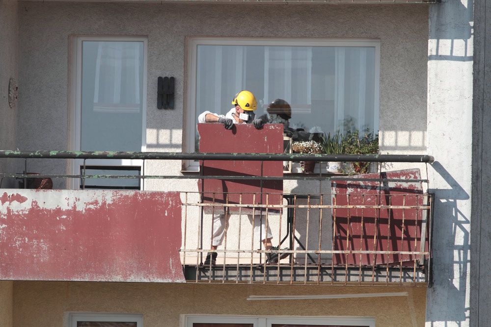 A Man Wearing A Hard Hat Sits On A Balcony — Ballina Demolitions In Goonellabah, NSW