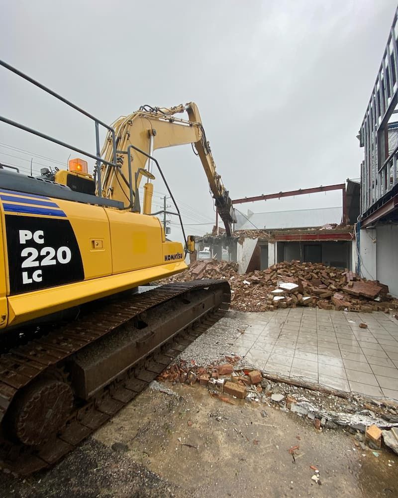 A Yellow Excavator Demolishes a Building