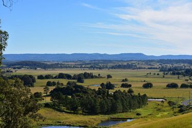 A View Of A Lush Green Field With Trees And Mountains — Ballina Demolitions In Kyogle, NSW