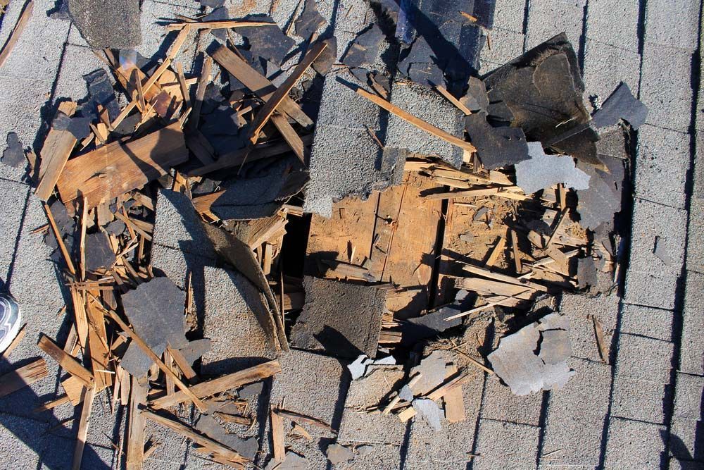 A Pile Of Broken Shingles On A Brick Roof — Ballina Demolitions In Murwillumbah, NSW