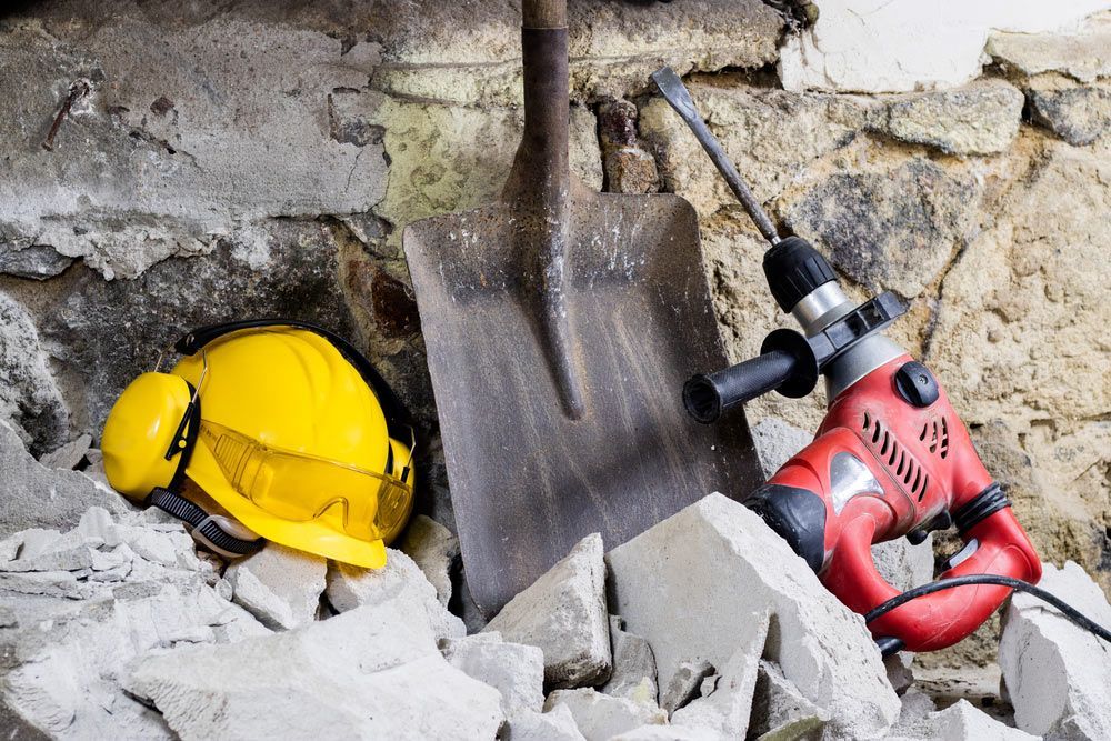A Hard Hat And A Shovel Are Laying On A Pile Of Bricks — Ballina Demolitions In Kyogle, NSW