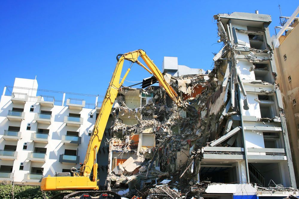 A Large Yellow Crane Is Demolishing A Building — Ballina Demolitions In Lismore, NSW