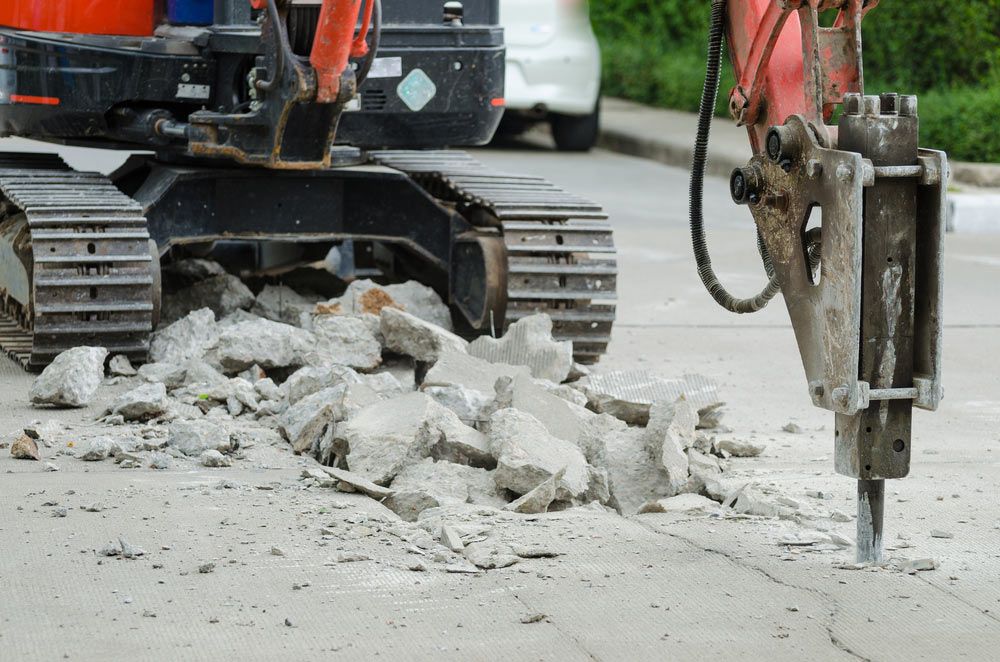A Bulldozer Is Breaking Up Concrete With A Hammer — Ballina Demolitions In Murwillumbah, NSW