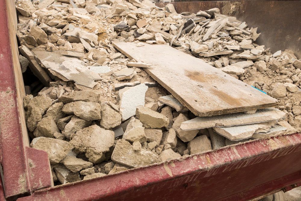 A Dumpster Filled With Rocks And A Piece Of Wood — Ballina Demolitions In Byron Bay, NSW