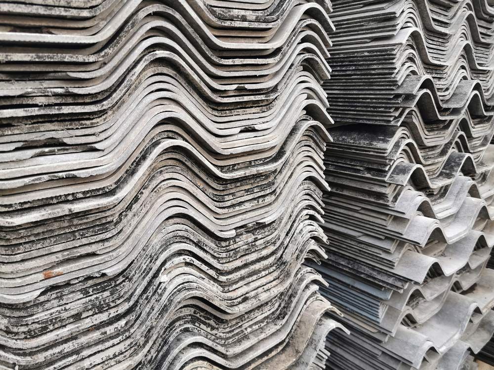 A Close Up Of A Pile Of Asbestos Roof Tiles Stacked On Top Of Each Other — Ballina Demolitions In Yamba, NSW