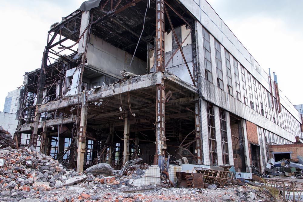 A Large Building Is Being Demolished And There Is A Pile Of Rubble In Front Of It — Ballina Demolitions In Lismore, NSW