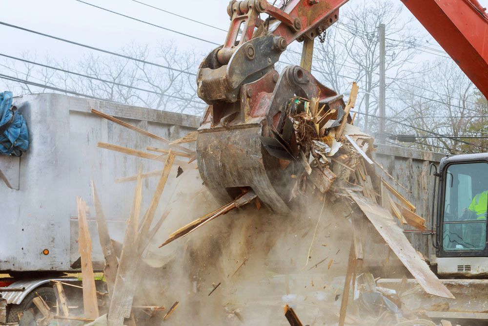 A Bulldozer Is Destroying A Building With A Bucket Full Of Wood — Ballina Demolitions In Tweed Heads, NSW