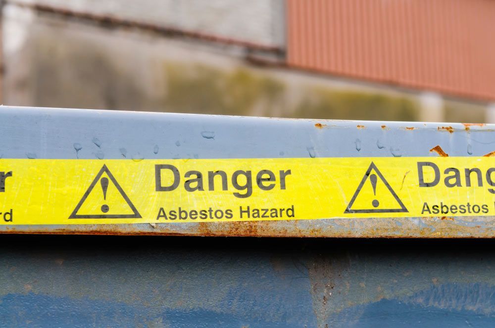 A Close Up Of A Danger Asbestos Hazard Sign On A Metal Surface — Ballina Demolitions In East Wardell, NSW