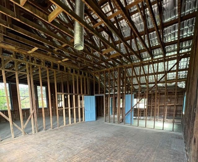 A Large Empty Room With Wooden Beams And A Metal Roof — Ballina Demolitions In East Wardell, NSW
