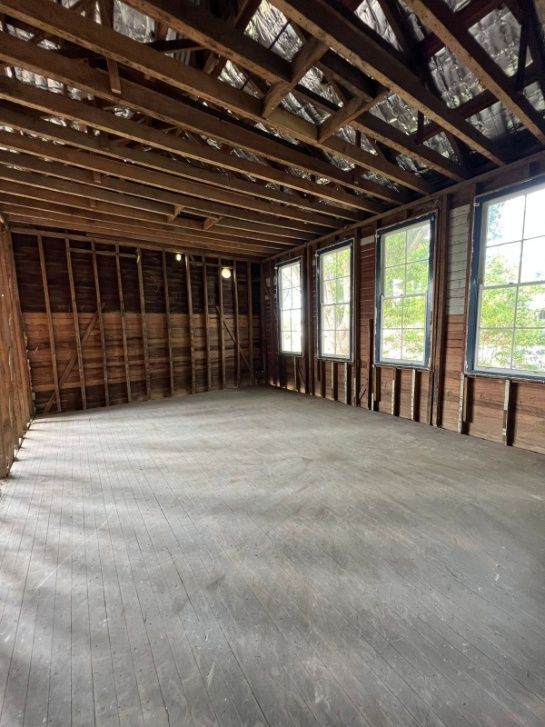 A Large Empty Room With A Lot Of Windows And Wooden Beams — Ballina Demolitions In East Wardell, NSW
