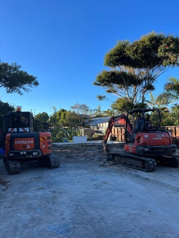 Two Excavators Are Parked Next To Each Other In A Gravel Lot — Ballina Demolitions In East Wardell, NSW