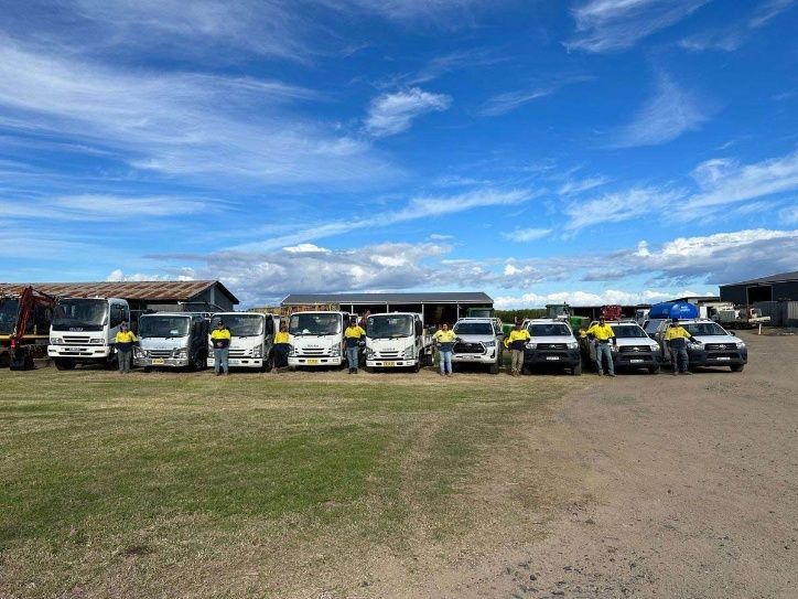 A Group Of Men Are Standing In Front Of A Row Of Trucks — Ballina Demolitions In East Wardell, NSW