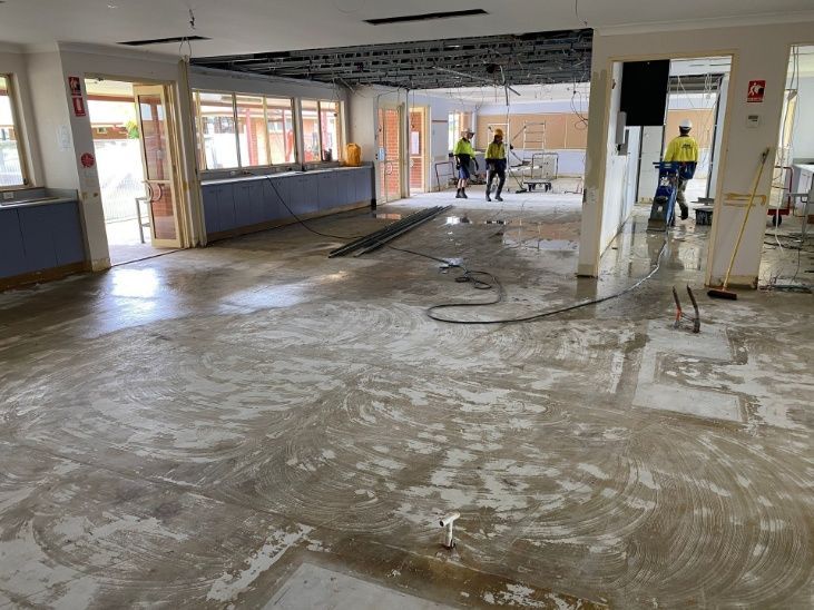A Large Empty Room With A Concrete Floor And People Standing Around It — Ballina Demolitions In East Wardell, NSW