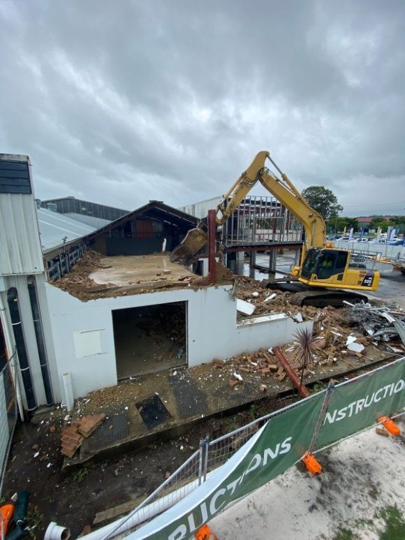 A Large Yellow Excavator Is Demolishing A Building — Ballina Demolitions In East Wardell, NSW